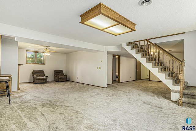 interior space with stairway, ceiling fan, carpet flooring, and visible vents