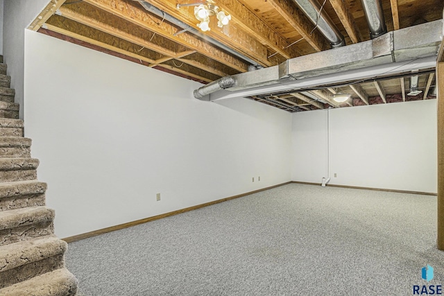 finished basement with baseboards, carpet flooring, and stairs