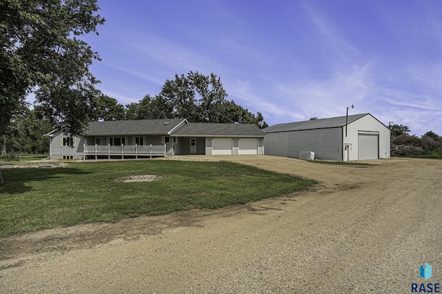 view of front of home featuring a garage, a front lawn, and covered porch