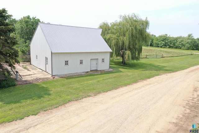 view of pole building with a lawn and fence