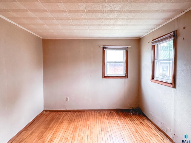 120 SW 2nd St Unit 1 & 2, Wentworth, SD 57075 - empty room with a healthy amount of sunlight, baseboards, crown molding, and wood-type flooring