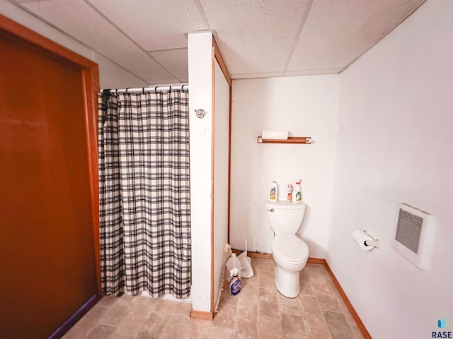120 SW 2nd St Unit 1 & 2, Wentworth, SD 57075 - full bath featuring heating unit, toilet, baseboards, a shower with shower curtain, and a paneled ceiling