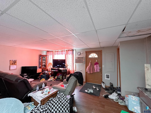 120 SW 2nd St Unit 1 & 2, Wentworth, SD 57075 - living room with a wall mounted air conditioner, a drop ceiling, and wood finished floors