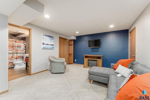 living area featuring carpet floors, recessed lighting, baseboards, and a glass covered fireplace