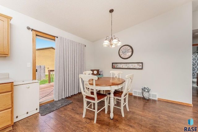 dining area featuring visible vents, a chandelier, wood finished floors, and vaulted ceiling