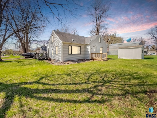 409 Boxelder St, Valley Springs, SD 57068 - back of house at dusk with a chimney, a lawn, and a deck