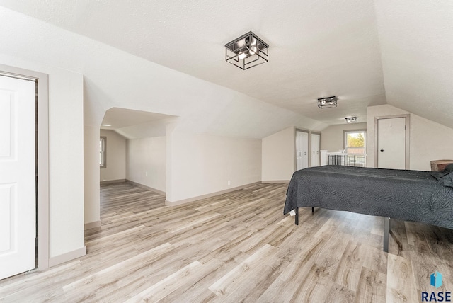 409 Boxelder St, Valley Springs, SD 57068 - bedroom with baseboards, arched walkways, lofted ceiling, and wood finished floors