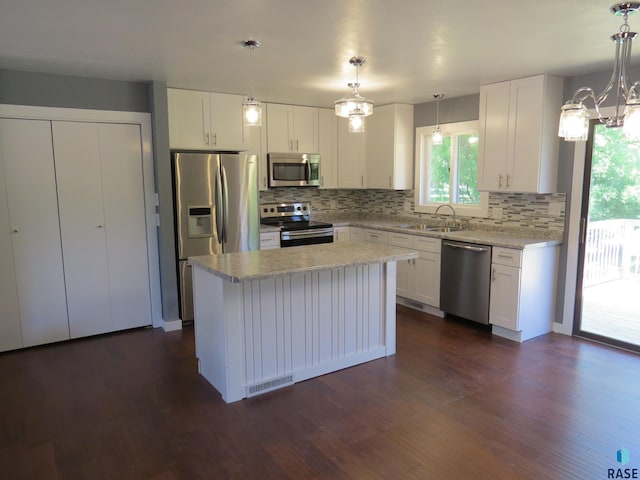 kitchen with a sink, appliances with stainless steel finishes, backsplash, and a chandelier