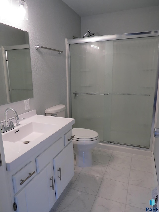 bathroom with toilet, a shower stall, marble finish floor, and vanity