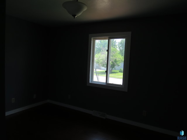 unfurnished room with baseboards and visible vents