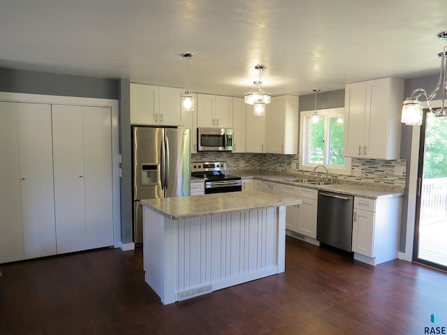 kitchen featuring a sink, appliances with stainless steel finishes, tasteful backsplash, and a chandelier