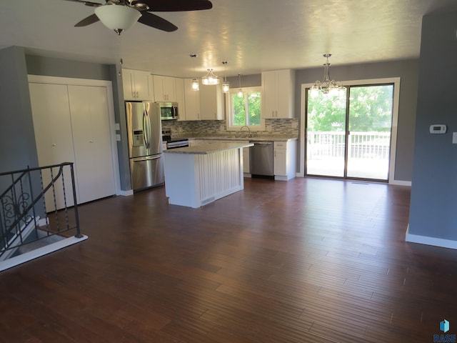 kitchen featuring a kitchen island, stainless steel appliances, white cabinetry, and tasteful backsplash