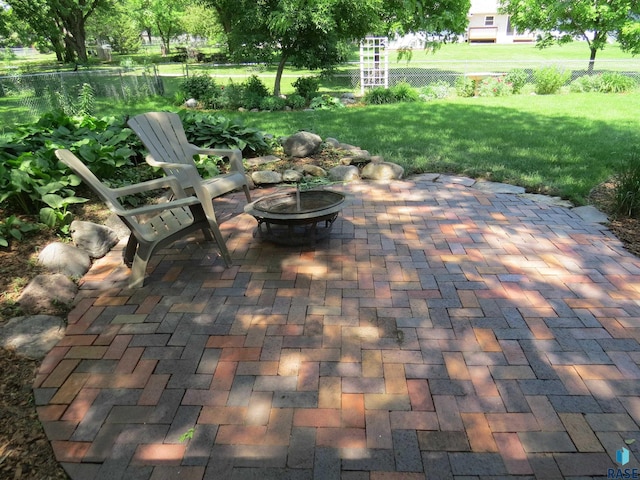 view of patio featuring a fire pit and fence