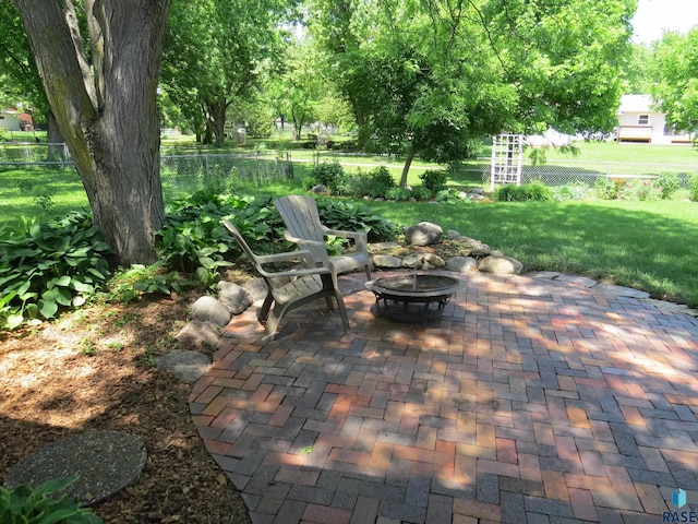 view of patio featuring an outdoor fire pit and fence