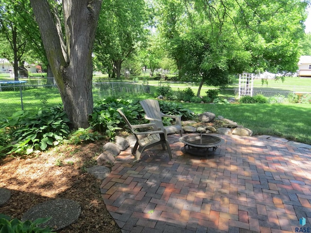 view of patio with an outdoor fire pit and fence