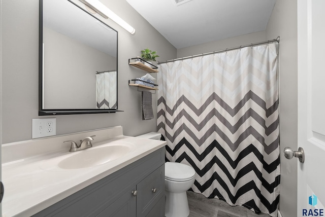 bathroom with vanity, toilet, wood finished floors, and a shower with shower curtain