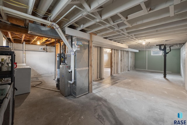 unfinished basement featuring heating unit and gas water heater