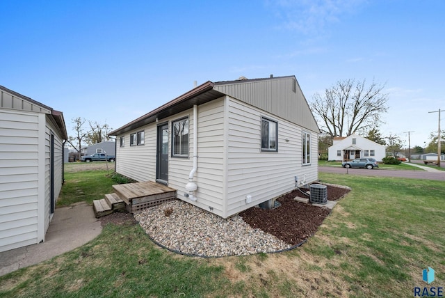 view of side of home with a lawn and central AC