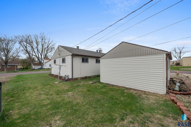 view of side of property with a yard and an outdoor structure