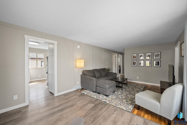 living room with baseboards and wood finished floors