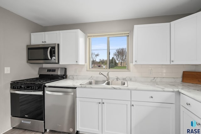 kitchen featuring a sink, appliances with stainless steel finishes, and white cabinets