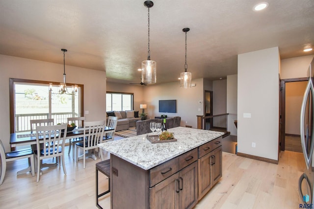 kitchen featuring a notable chandelier, light wood-style floors, a center island, recessed lighting, and pendant lighting
