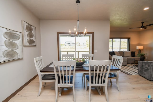 dining area featuring light wood-type flooring, recessed lighting, baseboards, and ceiling fan with notable chandelier