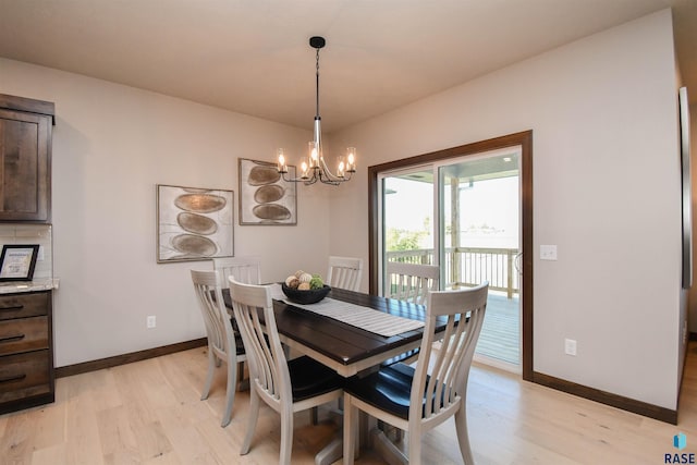 dining room featuring baseboards, an inviting chandelier, and light wood-style flooring