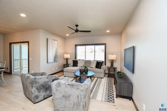 living area with light wood-type flooring, recessed lighting, and baseboards