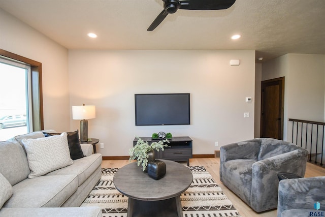 living area with baseboards, ceiling fan, recessed lighting, and light wood-style flooring