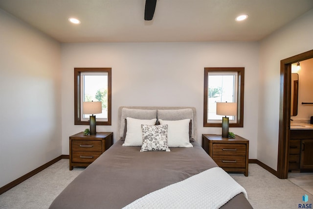 bedroom with baseboards, ensuite bathroom, recessed lighting, and light colored carpet