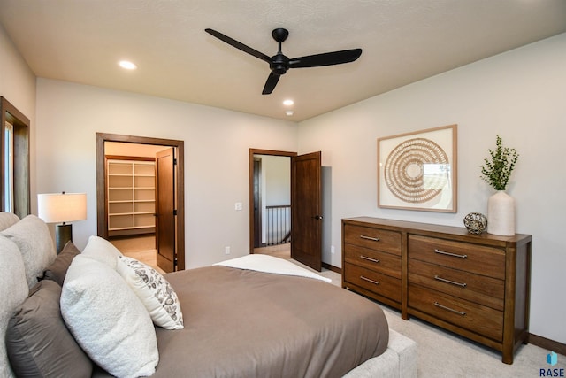 bedroom featuring ceiling fan, light carpet, recessed lighting, baseboards, and a spacious closet