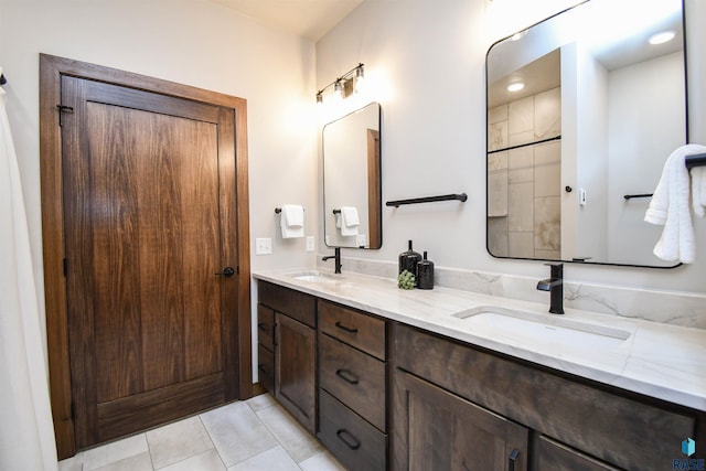 full bath featuring tile patterned flooring, a sink, and double vanity