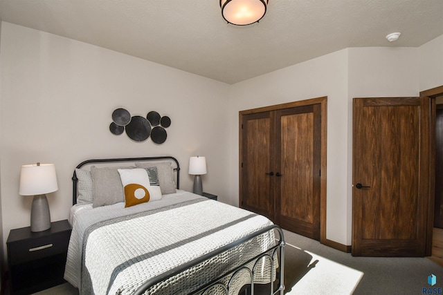 carpeted bedroom featuring baseboards and a closet