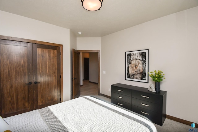 bedroom with a closet, baseboards, and carpet flooring