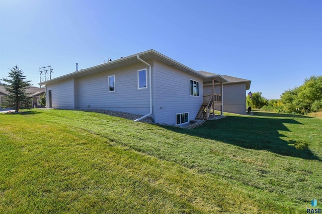 back of house with a lawn and stairway
