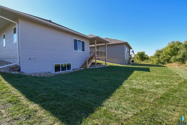 back of property featuring a lawn and stairway