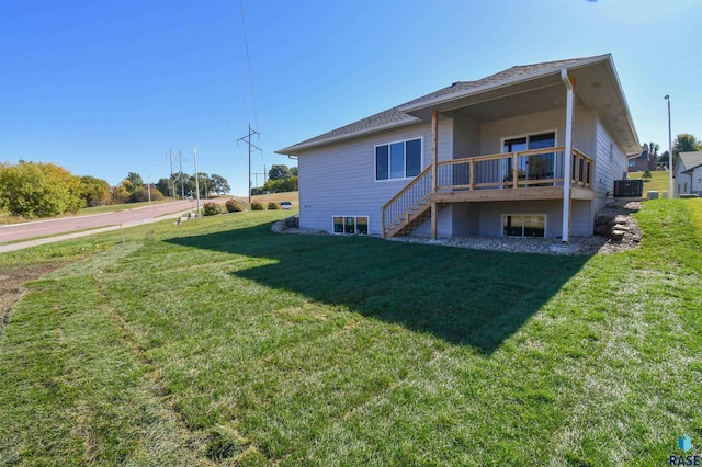 rear view of property with a deck, a yard, central AC, and stairway