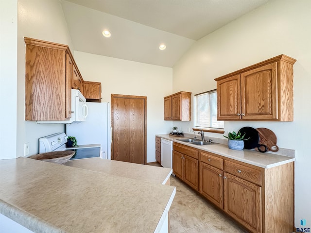 kitchen with a sink, light countertops, a peninsula, lofted ceiling, and white appliances