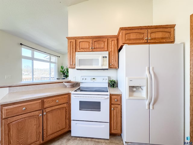 kitchen featuring light countertops, brown cabinets, and white appliances