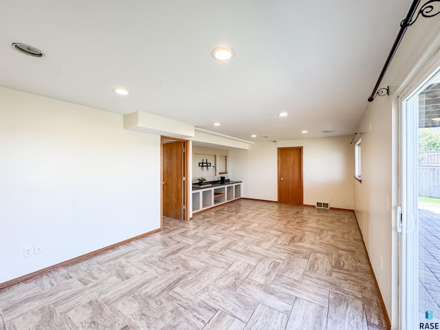 unfurnished living room featuring baseboards, recessed lighting, and visible vents