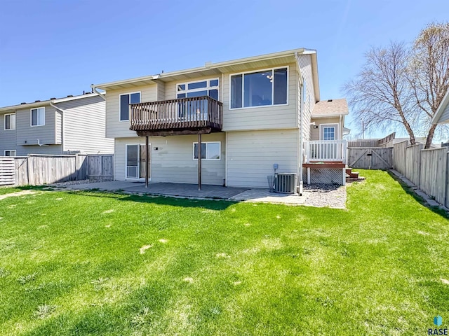 rear view of house featuring a lawn, central AC unit, a gate, a fenced backyard, and a patio