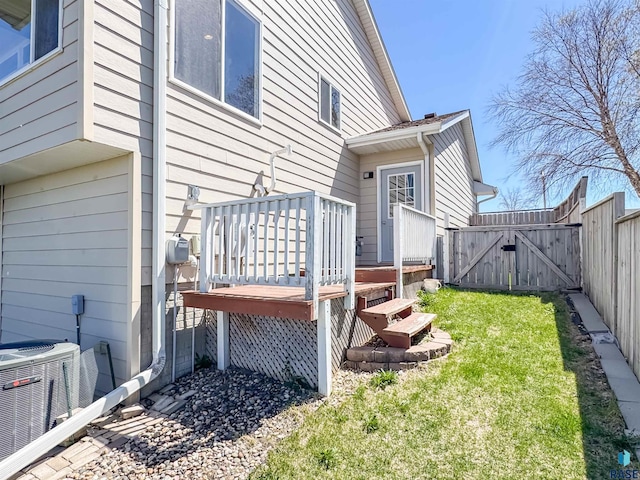 exterior space with a gate, fence, a deck, and cooling unit