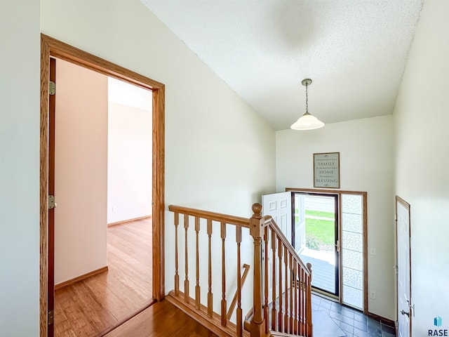 interior space with a textured ceiling, baseboards, and wood finished floors
