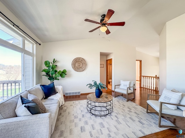 living room featuring a ceiling fan, baseboards, wood finished floors, lofted ceiling, and visible vents