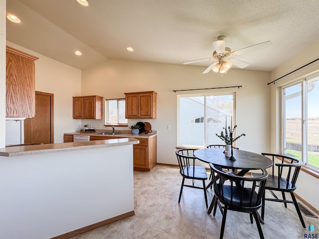 kitchen with brown cabinets, a ceiling fan, and a healthy amount of sunlight