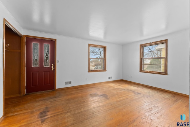 entrance foyer with visible vents, light wood finished floors, plenty of natural light, and baseboards