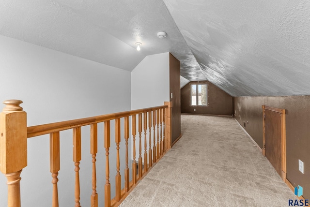 interior space featuring carpet flooring, a textured ceiling, and vaulted ceiling