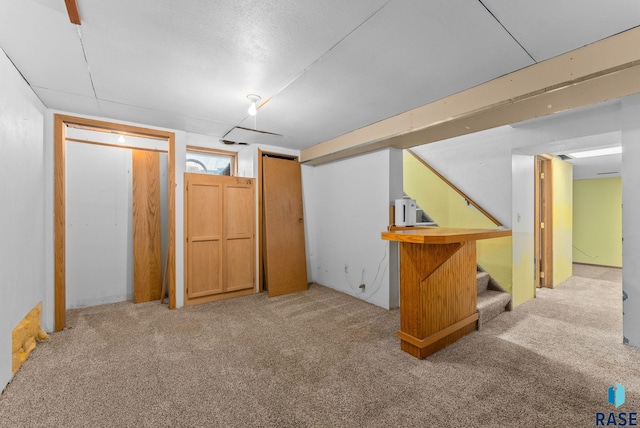 finished basement featuring stairway and carpet floors