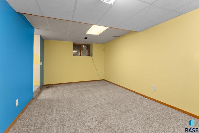 spare room featuring baseboards, carpet flooring, and a paneled ceiling